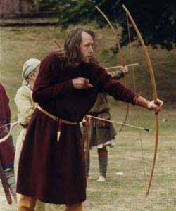 * Several archers at practice, the one in focus has fumbled the release, so the arrow is falling between his legs